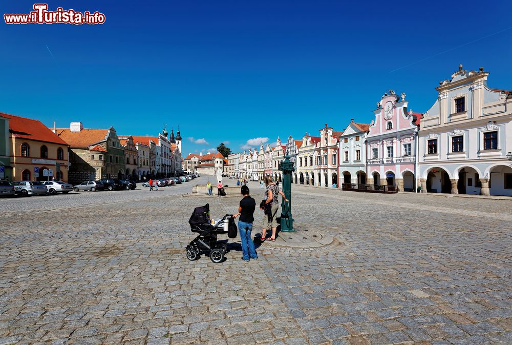 Immagine Una mamma con passeggino nella piazza di Telc, Repubblica Ceca. Le case in stile rinascimentale che si affacciano sull piazza hanno tutte la stessa altezza e la stessa superficie.