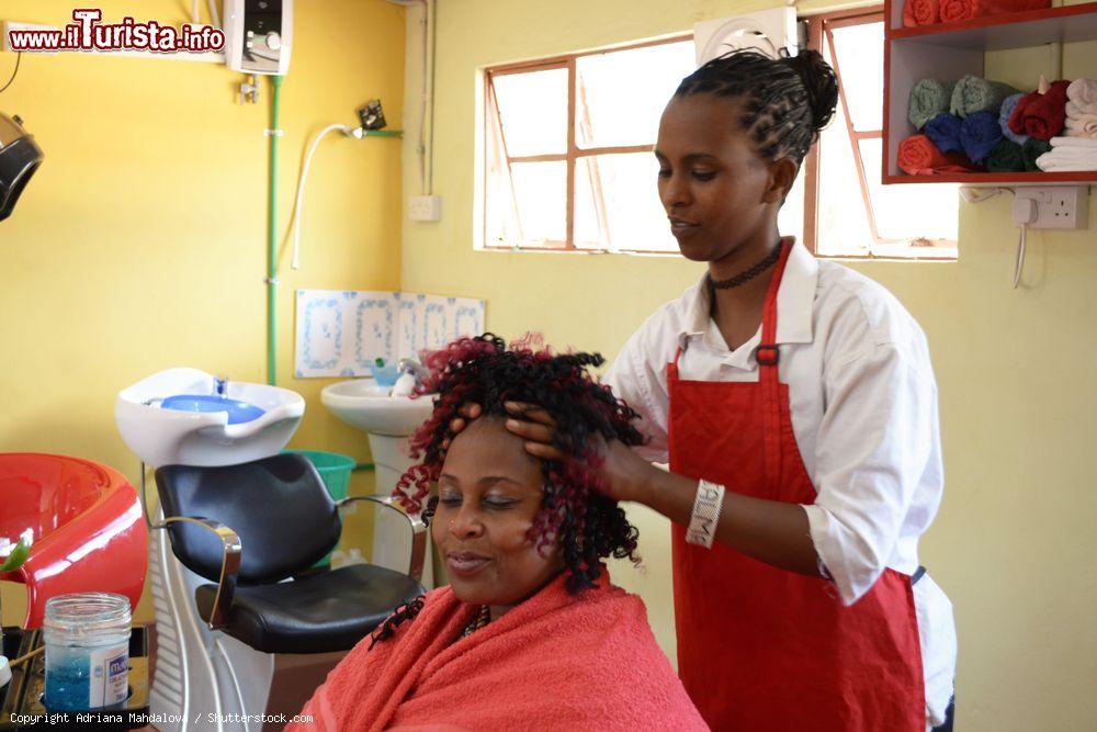 Immagine Marsabit, Kenya: una giovane ragazza realizza un'acconciatura nel centro di formazione professionale per ottenere l'abilitazione finale - © Adriana Mahdalova / Shutterstock.com