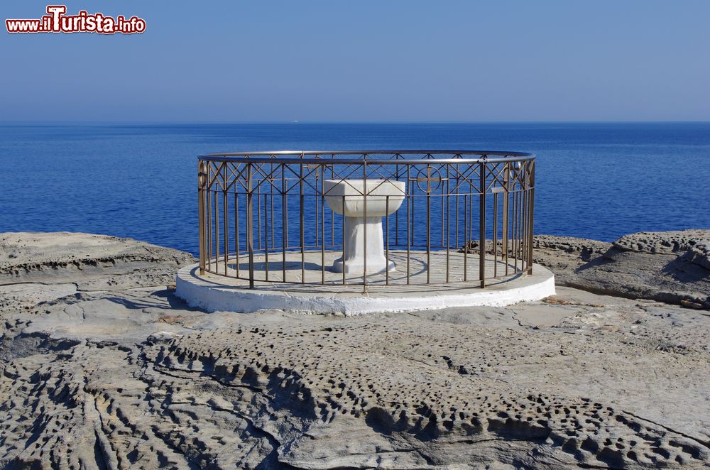 Immagine Un monumento nei pressi della chiesa di Panaghia Chrisopigi sull'isola di Sifnos, Grecia. La fontana, in marmo bianco, si trova sul lato orientale della penisola di Chrisopigi.