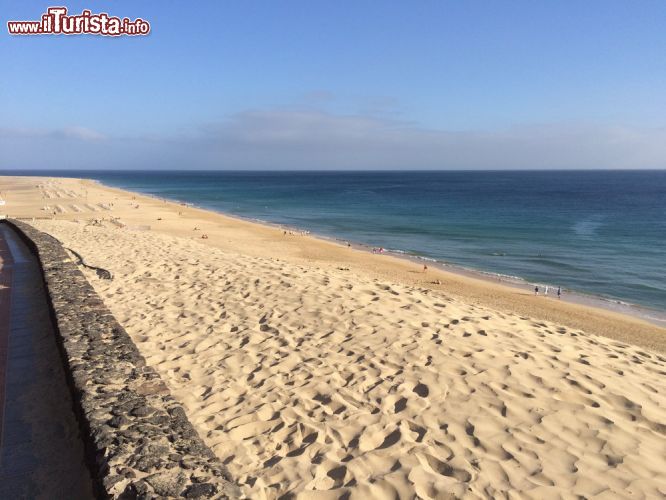 Immagine La famosa sabbia bianca di Morro Jable, Fuerteventura, Spagna - Guardando questa fotografia sembra che questa spiaggia non stia aspettando altro di essere calpestata. Che si tratti di bambini, sposini, amici, famiglie, questa distesa sembra fatta apposta per accogliere chiunque. La sabbia bianca qui a Morro Jable si estende per quattro chilometri circa.