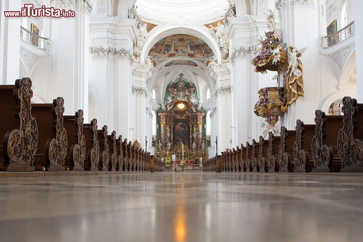 Immagine Navata centrale della basilica di Weingarten, Germania - I banchi in legno finemente decorati impreziosiscono la navata centrale di San Martino. Sul lato destro risalta il bel pulpito dorato con gli angeli