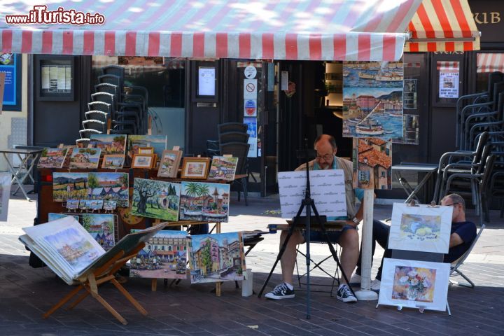 Immagine Un pittore in Corso Saleya a Nizza, Francia. Oltre a ospitare bancarelle di fiori, quest'area pedonale della città è anche perfetta cornice per artisti e prodotti tipici.