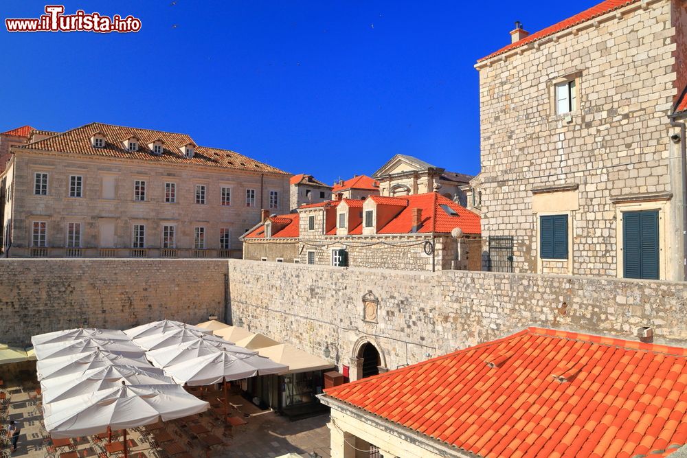 Immagine Ombrelloni lungo le mura e gli edifici della città vecchia di Dubrovnik, Croazia.
