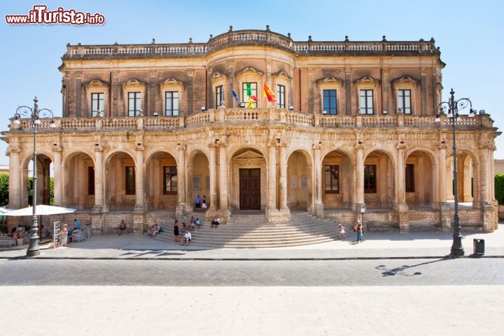 Immagine Palazzo Ducezio, sede del Municipio di Noto, in un soleggiato giorno d'estate - Palazzo Ducezio, attualmente sede del Municipio di Noto, è un bellissimo edificio costruito, in stile neoclassico, nel 1760, intitolato a Ducezio, re dei Siculi quattro secoli prima della nascita di Cristo, e al quale è inoltre dedicato un bellissimo affresco nella prestigiosa Sala degli Specchi.- © vvoe / Shutterstock.com