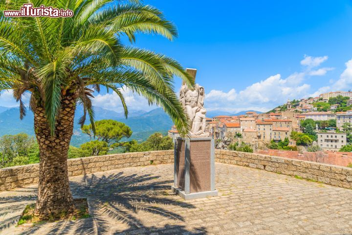 Immagine Palma e monumento nella cittadina di Sarténe, a metà strada da Ajaccio e Bonifacio, in Corsica (Francia) - foto © Shutterstock.com