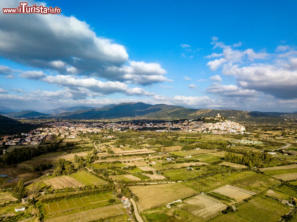 Immagine Panorama aereo di Posada, borgo della Baronia, Sardegna. Arroccato su una rupe, questo villaggio è dominato da un castello e ai suoi piedi si estende una valle verde che sfocia nel fiume turchese.