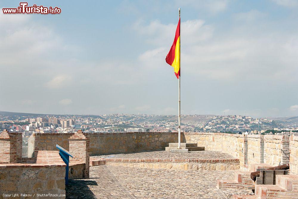 Immagine Panorama dall'alto di Melilla con la bandiera spagnola che sventola. Abitata da poco più di 80 mila persone, questa città sorge nei pressi del porto marocchino di Beni Ensar - © Pabkov / Shutterstock.com