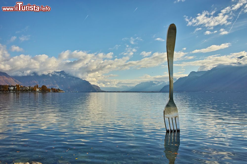 Immagine Panorama del lago di Ginevra dalla città di Vevey, Svizzera. Sulle sponde del bacino si trova il bizzarro monumento che ritrae una forchetta gigante.
