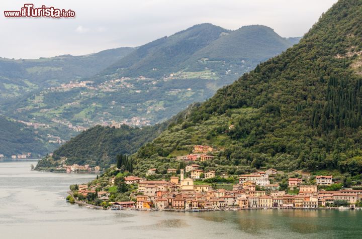 Immagine Panorama di Peschiera Maraglio, Lago d'Iseo. Una bella veduta di questo pittoresco borgo lombardo. Il centro storico si può visitare solo a piedi ammirandone così le strette viuzze e la chiesa di San Michele del XVII° secolo. Peschiera si trova vicinissimo a Sulzano, località sulla costa bresciana del lago Sebino - © Marco Saracco / Shutterstock.com