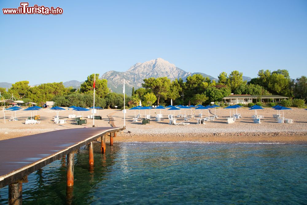 Immagine Panorama di spiaggia e pontile in legno a Tekirova, Turchia, con il Monte Olimpo sullo sfondo.