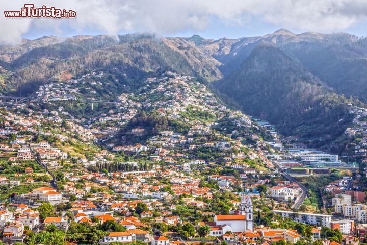 Immagine Panorama di Madeira e della sua capitale, Funchal (Portogallo) - Così piena la visione che suggerisce Madera che non si sa da quale parte cominciare a raccontarla. Sì perché oltre alle bellissime viste di cui l'oceano atlantico è complice, vi è anche la parte urbana che si presenta decisamente stimolante, come si può vedere dall'immagine. L'isola, con la sua edilizia così protettiva che abbraccia i centri storici, fa sembrare tutto incantato e fiabesco, come se accedervi fosse una magia - © Vlada Z / Shutterstock.com