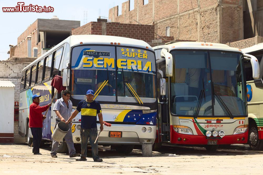 Immagine Persone intente a pulire due bus in una stazione di Chiclayo, Perù. La maggior parte del trasporto dei passeggeri del Sud America parte dal Perù - © Sven Schermer / Shutterstock.com