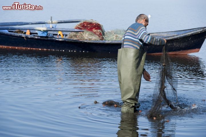 Immagine Un pescatore con le reti nel porto di Sant'Antioco in Sardegna - © Famed01 / Shutterstock.com