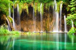 Le cascate nel verde del Parco Nazionale di Plitvice, Croazia - I 16 laghi che costituiscono l'area protetta di Plitvice si formano alla confluenza di due fiumi, il Bianco e il Nero, che ...