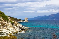 La costa nel Deserto degli Agriates, Corsica: la natura selvaggia si specchia nel Mar Mediterraneo, con ciò che resta di un'antica torre di avvistamento - la costa del Desert des ...