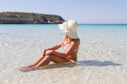 Donna in relax sulla spiaggia dei Conigli a Lampedusa ...