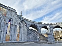 Il fianco della Basilica dell'Immacolata Concezione di Lourdes, la scalinata ed alcuni mosaici - © laurent dambies / Shutterstock.com