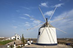 Un vecchio mulino a vento sulle colline di Castro Marim. Come le tipiche abitazioni del villaggio, anche i mulini a vento, che si stagliano sulla cima di dolci colline verdeggianti dell'Algarve, ...