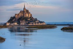 Alta marea a Mont-Saint-Michel in Normandia, Francia. Questa località ha le più alte maree sizigiali dell'Europa Continentale creando un panorama spettacolare - © neju/ ...