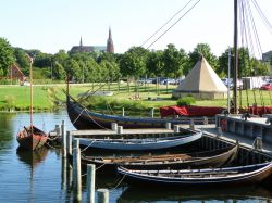 Barche ormeggiate al porto con sullo sfondo la celebre cattedrale di St. Luke a Roskilde, Danimarca.

