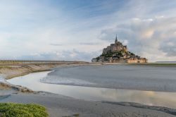 Un canale di marea con l'abbazia di Mont-Saint-Michel sullo sfondo, Normandia, Francia - © Rudy Mareel / Shutterstock.com