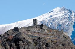 Il Castello di Chenal a Montjovet in Valle d'Aosta con i monti innevati sullo sfondo.
