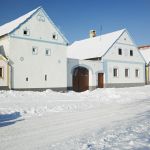 Il villaggio di Holasovice in inverno, Repubblica Ceca. Una suggestiva immagine degli edifici innevati nel cuore del paese fatto di villette, fattorie e giardini.
