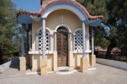 Ingresso a una chiesetta di Katomeri a Meganissi, Grecia - Un grazioso colonnato circonda questa piccola chiesetta del villaggio di Katomeri sull'isola di Meganissi. Finestre finemente decorate ...
