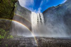 La cascata di Skogafoss con l'arcobaleno, Islanda. Situata nel sud dell'isola vicino alla località di Skogar, è originata dal fiume Skogaa: è alta 60 metri e alta ...