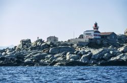 La costa rocciosa dell'isola di Lavezzi con il faro visti dal Mar Tirreno, Corsica.
