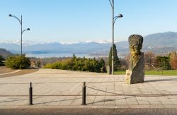La statua dedicata ad Antonio Ghiringhelli in Piazza Belvedere ad Azzate, sullo sfondo il Lago di Varese - © elesi / Shutterstock.com