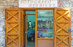 Un accostamento insolito: negozio di un fotografo e barbiere nel borgo di Acciaroli in Campania - © Gimas / Shutterstock.com