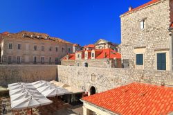 Ombrelloni lungo le mura e gli edifici della città vecchia di Dubrovnik, Croazia.

