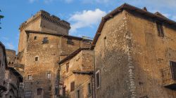 Palazzi di epoca medievale nel centro città di Sermoneta con uno scorcio del castello di Caetani sullo sfondo, Lazio.

