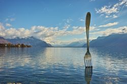 Panorama del lago di Ginevra dalla città di Vevey, Svizzera. Sulle sponde del bacino si trova il bizzarro monumento che ritrae una forchetta gigante. 



