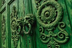 Particolare di un'antica porta in legno nella città di Venafro, Molise. I batacchi a forma di leone impreziosiscono questa porta d'ingresso decorata.



