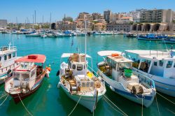 Porto di Heraklion, Creta - Le barche ormeggiate nel porto della città con sullo sfondo case e abitazioni che si affacciano sulle acque del Mar Mediterraneo: Heraklion è oggi un ...