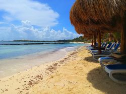 Puerto Aventuras, Riviera Maya (Messico): acqua azzurra del Mare dei Caraibi, sabbia bianca e ombrelloni di un resort in una giornata estiva.

