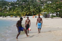 Ragazzi giocano a pallone a Grand Anse Beach, Grenada, in una giornata di sole.  A circa 5 km a sud di St.Georges si trova la spiaggia più famosa e lunga (3 km) della cittadina: ...