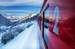 Uno scorcio del paesaggio invernale e innevato della Svizzera dal finestrino del Glacier Express. Le moderne e panoramiche carrozze permettono di ammirare da vicino gli scenari offerti: foreste ...
