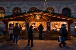 Shopping al mercatino di Natale di Bologna, Emilia-Romagna, by night. Sotto i portici e nelle piazze della città si ripropongono ormai da anni i tradizionali mercatini natalizi con bancarelle ...