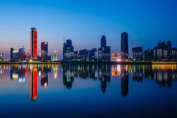 Skyline cittadina notturna di Nanchang con i grattacieli riflessi nel fiume, Cina.



