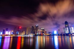 Skyline e grattacieli lungo la costa della città di Qingdao, Cina, fotografati di notte. Riparata a nord est dalle montagne e circondata dalla baia di Jaozhou, di Laoshan e dal Mar Giallo, ...