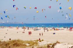 Sulla spiaggia di Tarifa con il kitesurf, Spagna. Aquiloni colorati su questo tratto di costa litoranea dell'Andalusia, da sempre zona frequentata dagli apapssionati di questo sport per ...
