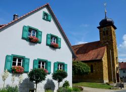Tipica casa bavarese con finestre in legno color smeraldo a Frankendorf, nei pressi di Bamberga, Germania.

