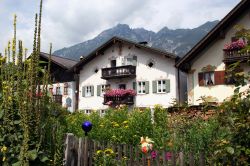 Tradizionali case bavaresi con fiori nel villaggio di Garmisch-Partenkirchen, Baviera (Germania). Sullo sfondo, i monti Ammergebirge. 
