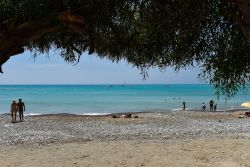 Turisti in relax prendono il sole e nuotano nella baia di Pissouri, isola di Cipro - © salajean / Shutterstock.com