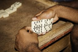 Un giovane uomo gioca con il domino in un villaggio nei pressi di Negril, Giamaica.


