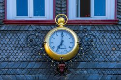 Un grande orologio sulla facciata di una casa nella città di Goslar, Germania.


