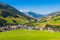 Un pittoresco scorcio estivo del villaggio austriaco di Saalbach circondato da prati verdi, Tirolo.
